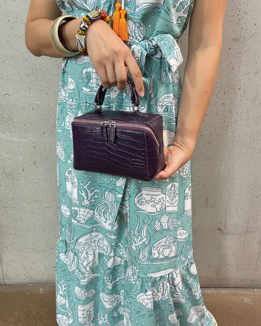 Person holding a purple wallet with a colorful background