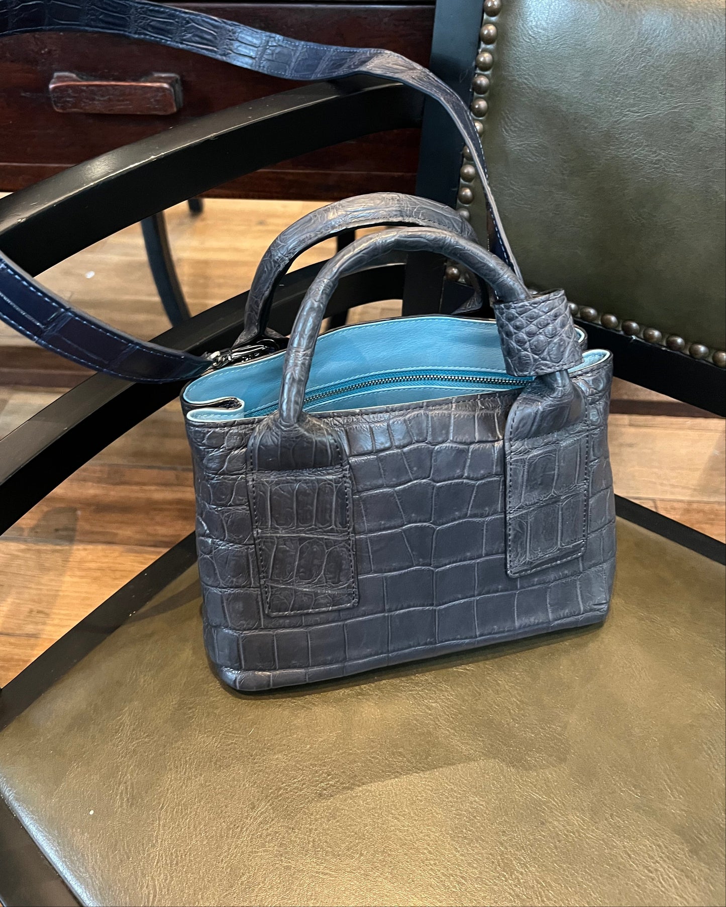 Gray handbag with a textured pattern on a wooden chair