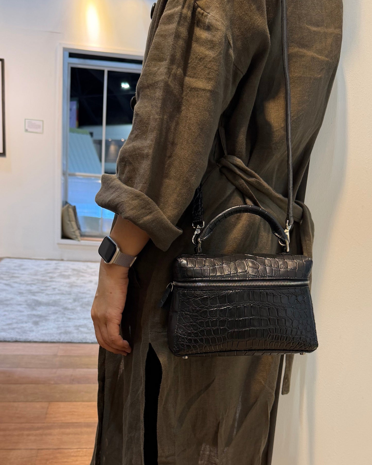 Person with dark coat carrying a black sling bag