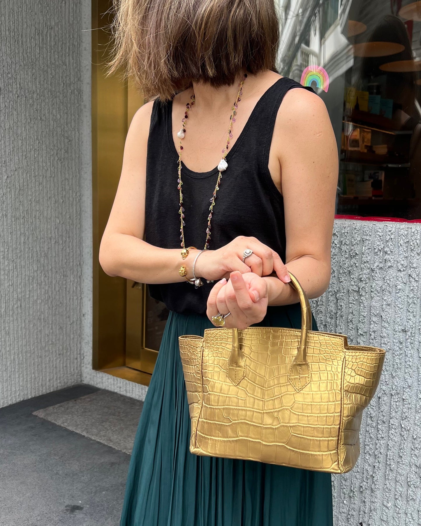 Woman holding a gold handbag in an urban setting