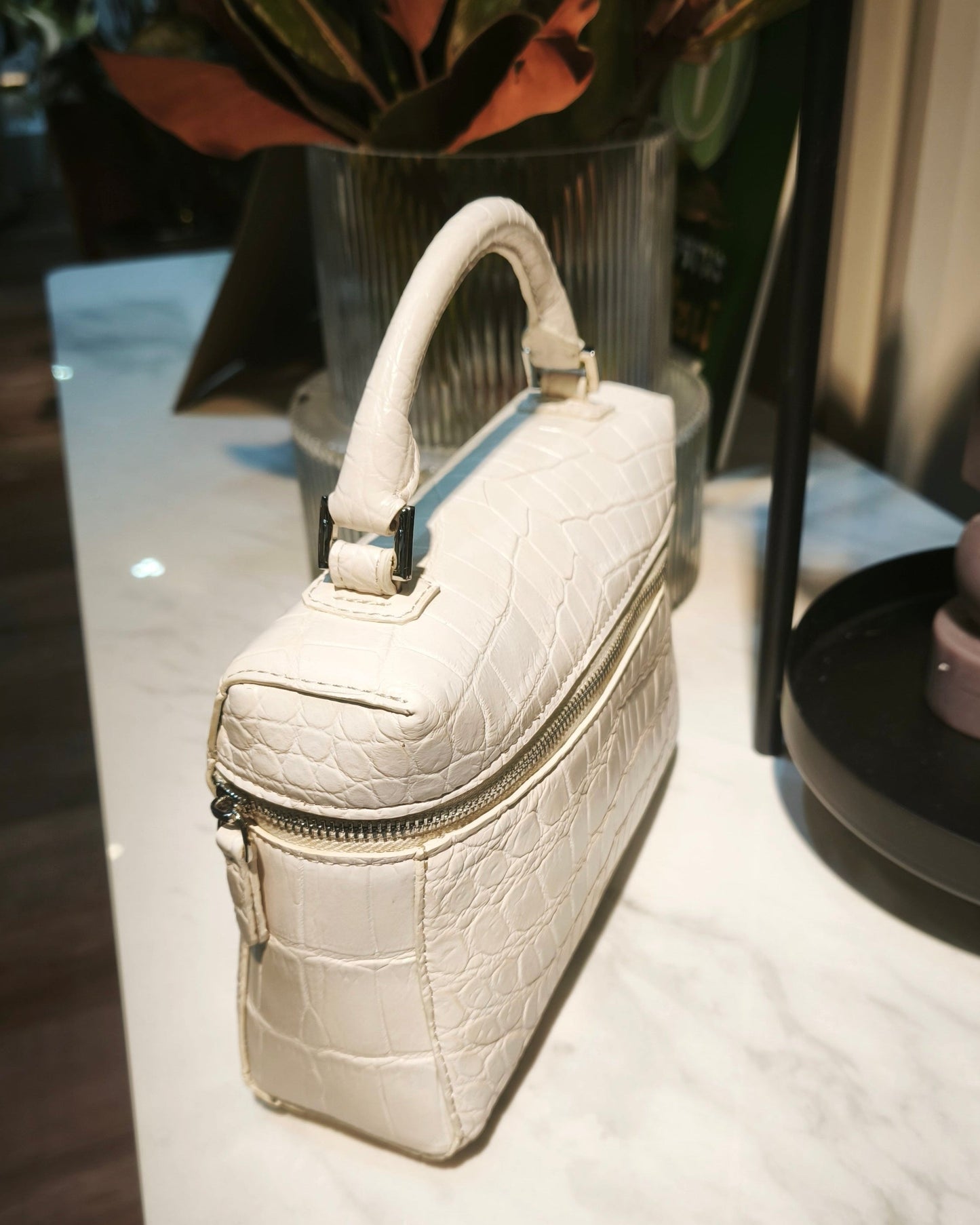 White handbag on a white surface with a blurred background