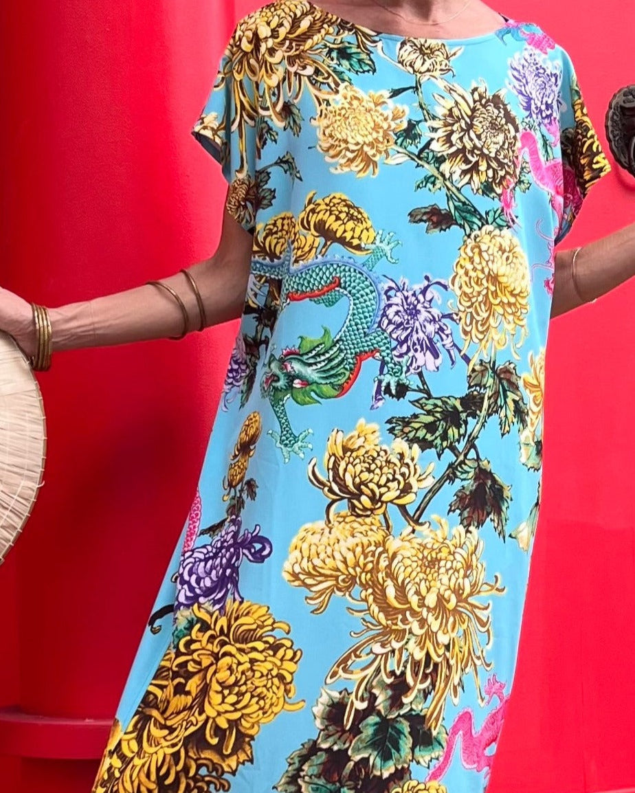 Colorful floral dress with a dragon design on a red background