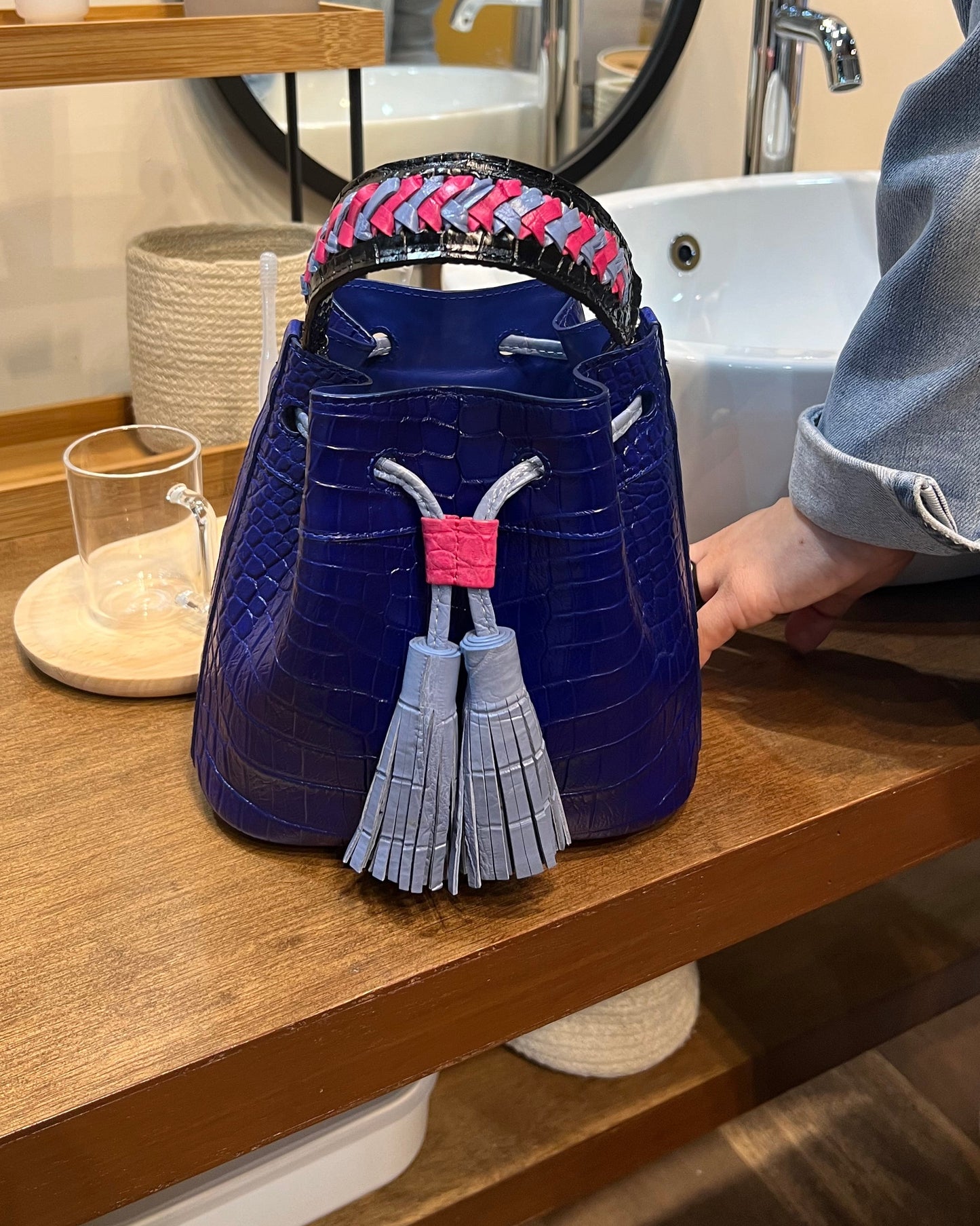 Blue handbag with tassels on a wooden surface