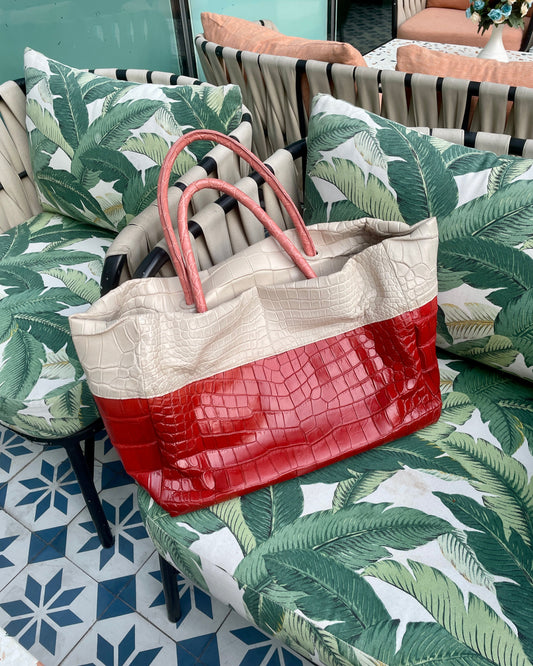 Tote bag with red and beige design on a patterned chair