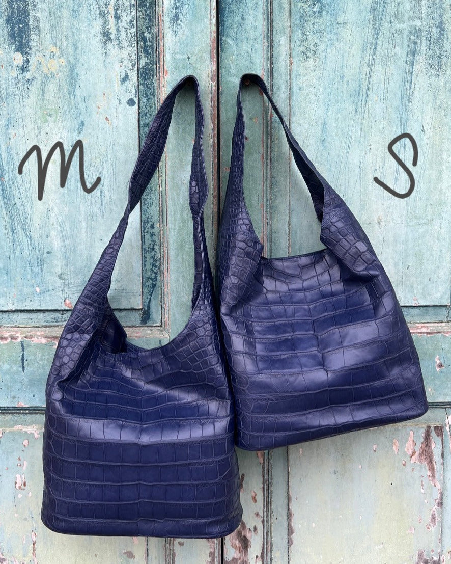Two navy blue handbags on a rustic wooden surface with 'm' and 's' visible.